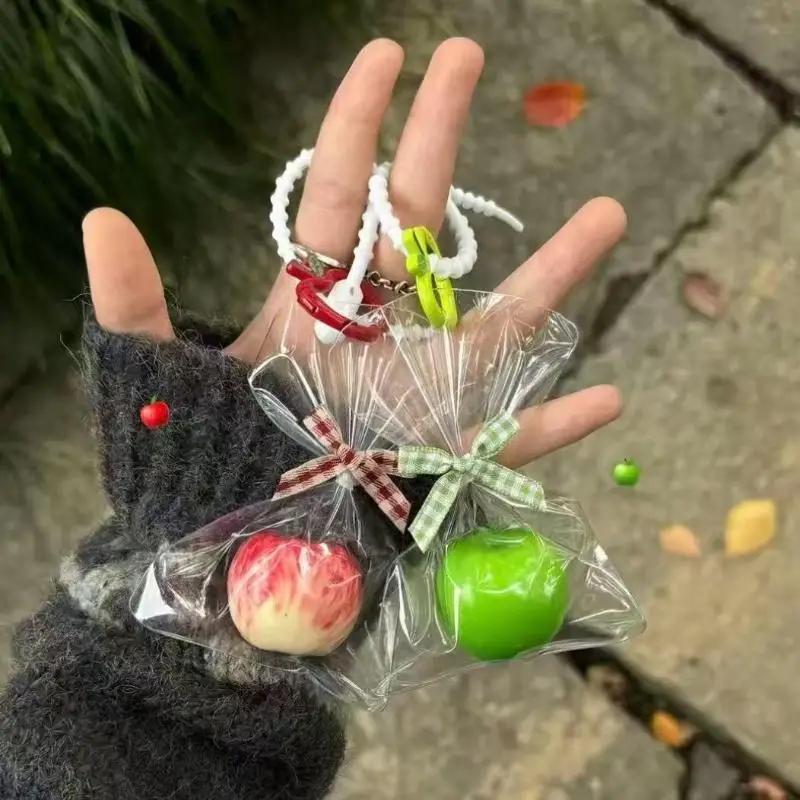 Porte-clés mignon du père noël sur une pomme d'hiver ; Accessoire de sac de Noël en résine de dessin animé et cadeau de fête pendentif d'arbre de Noël unique